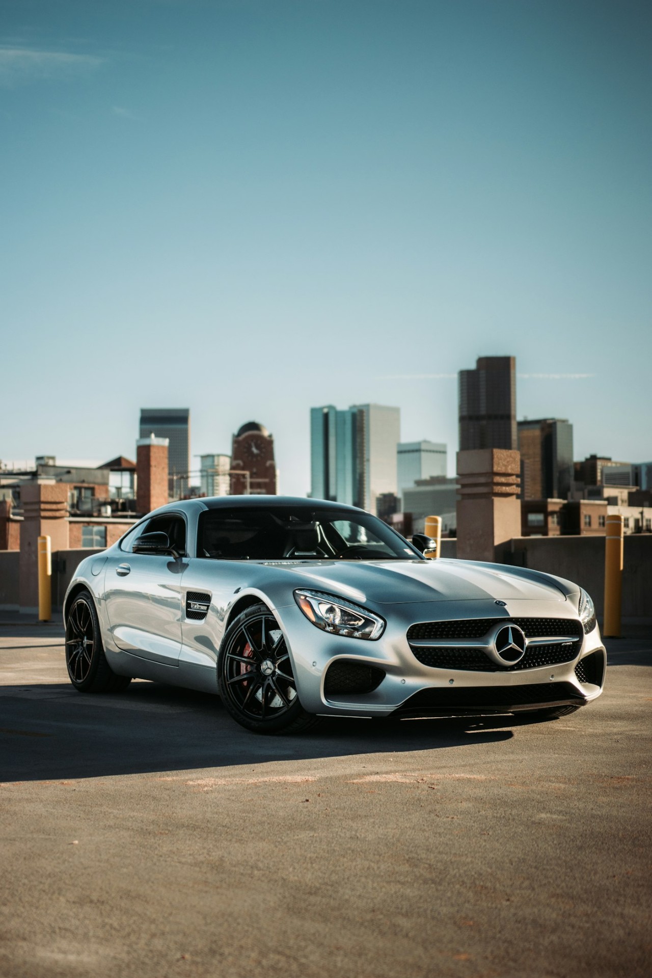 Mercedes-AMG GT argentée devant une skyline urbaine